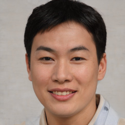 Joyful asian young-adult male with short  brown hair and brown eyes