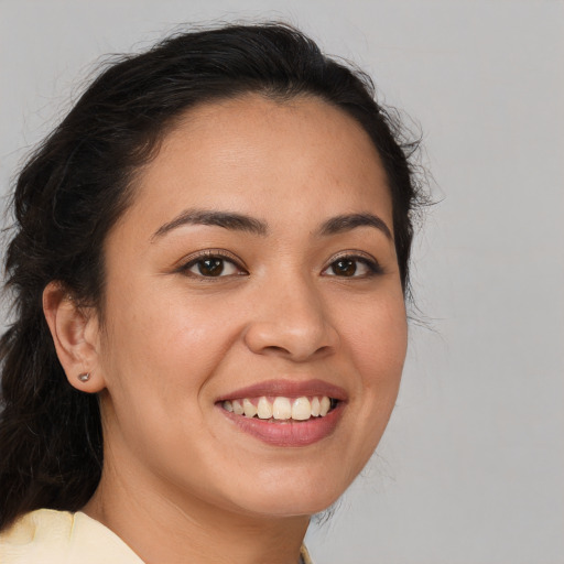 Joyful latino young-adult female with long  brown hair and brown eyes