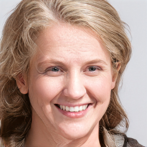 Joyful white adult female with medium  brown hair and blue eyes