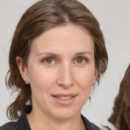 Joyful white adult female with medium  brown hair and grey eyes