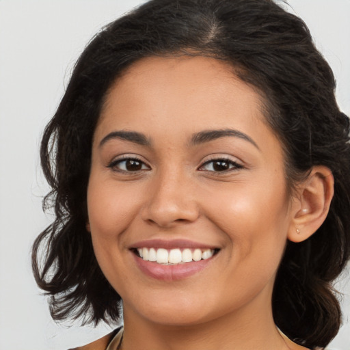 Joyful latino young-adult female with long  brown hair and brown eyes