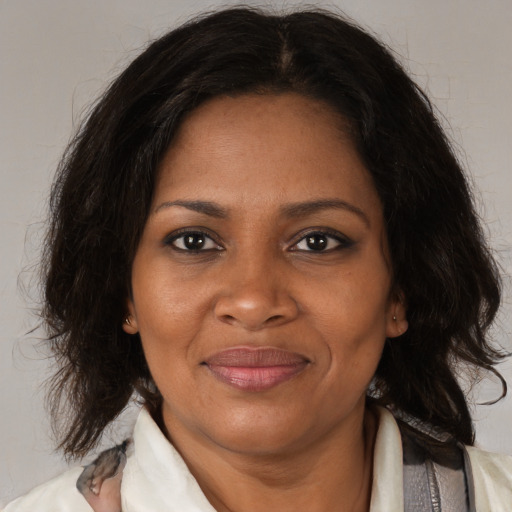 Joyful black adult female with medium  brown hair and brown eyes