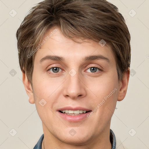 Joyful white young-adult male with short  brown hair and grey eyes