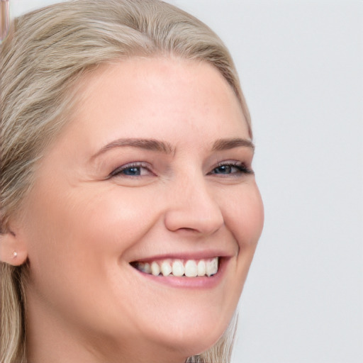 Joyful white young-adult female with long  brown hair and blue eyes