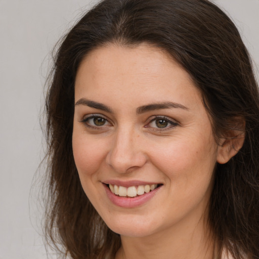 Joyful white young-adult female with long  brown hair and brown eyes