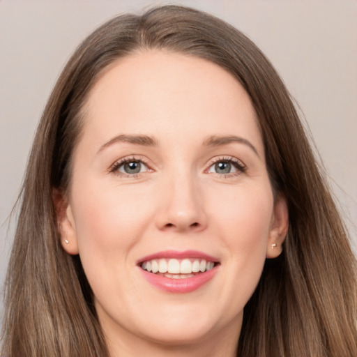 Joyful white young-adult female with long  brown hair and grey eyes