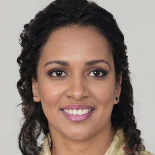 Joyful black young-adult female with long  brown hair and brown eyes