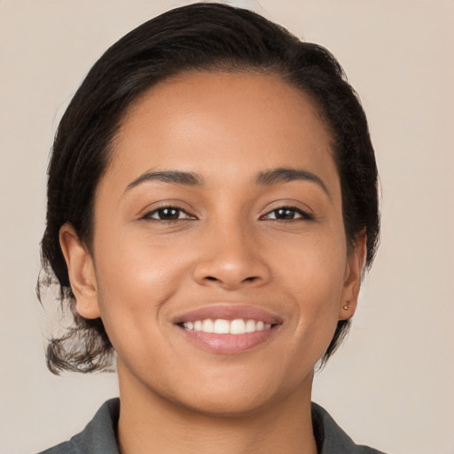 Joyful latino young-adult female with medium  brown hair and brown eyes