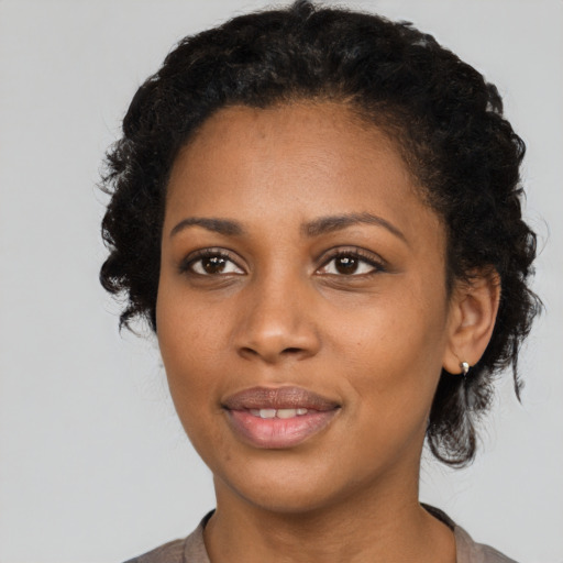 Joyful black young-adult female with short  black hair and brown eyes