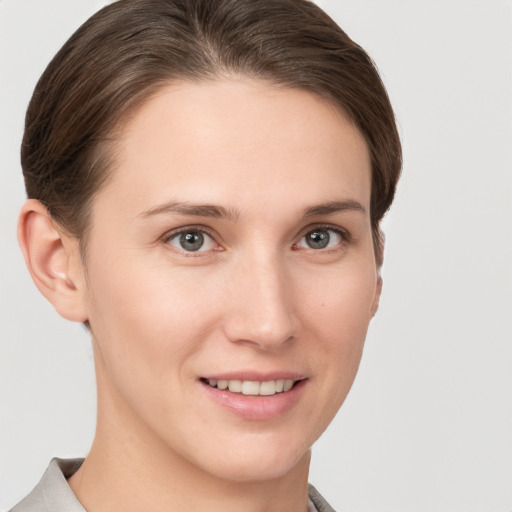 Joyful white young-adult female with short  brown hair and grey eyes