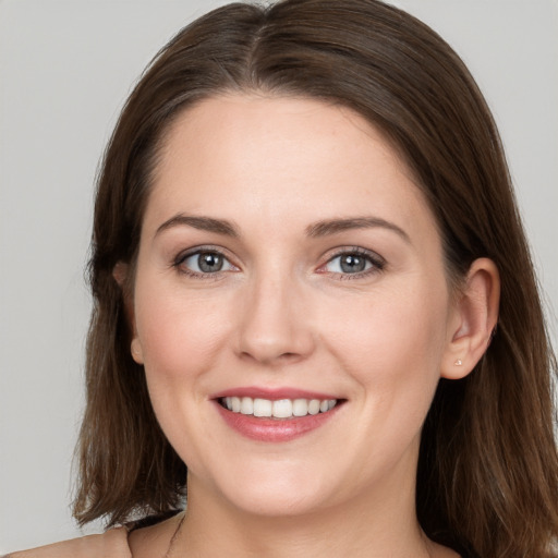 Joyful white young-adult female with long  brown hair and grey eyes