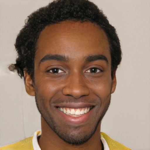 Joyful black young-adult male with short  black hair and brown eyes