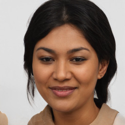 Joyful latino young-adult female with medium  brown hair and brown eyes