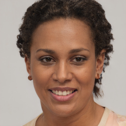 Joyful black adult female with short  brown hair and brown eyes