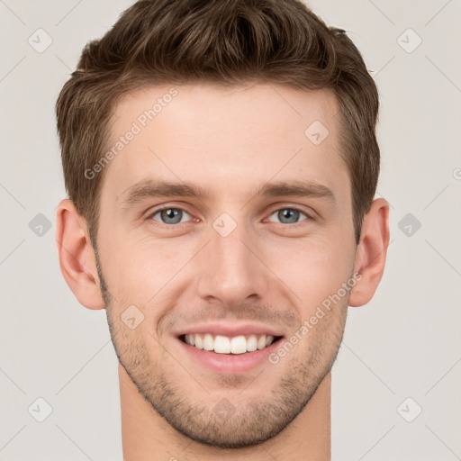 Joyful white young-adult male with short  brown hair and grey eyes