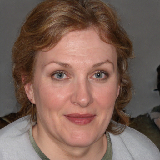 Joyful white adult female with medium  brown hair and blue eyes