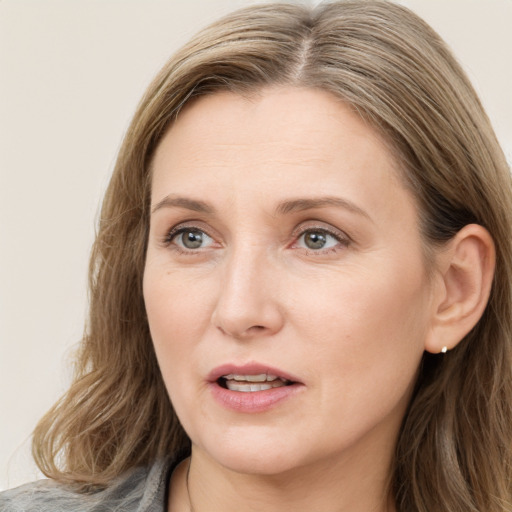 Joyful white adult female with medium  brown hair and blue eyes