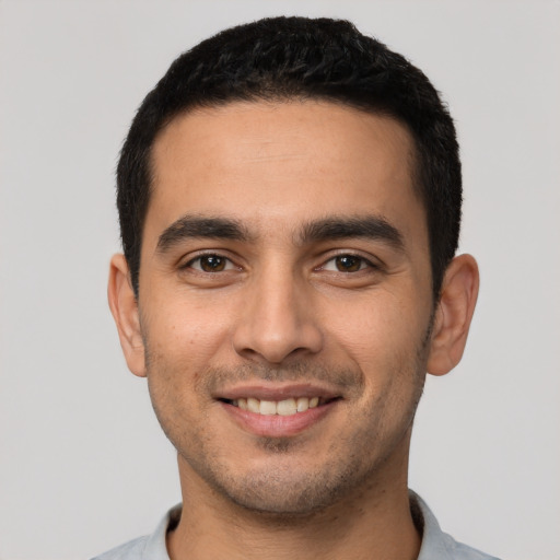 Joyful latino young-adult male with short  black hair and brown eyes