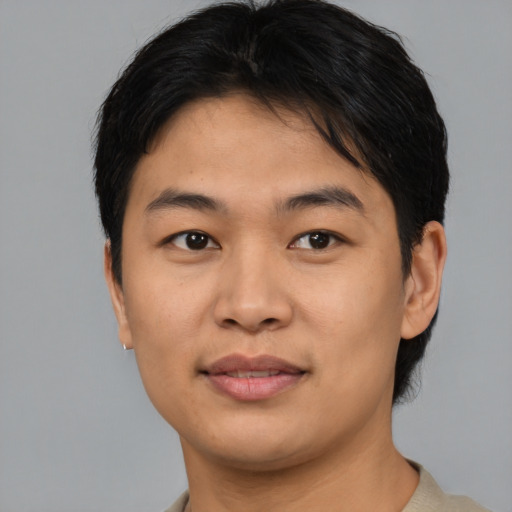 Joyful asian young-adult male with short  brown hair and brown eyes