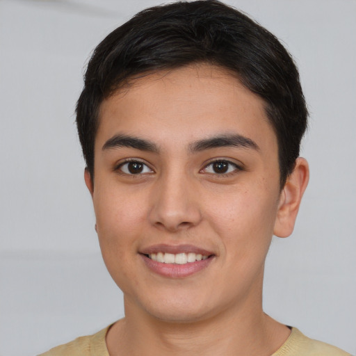 Joyful latino young-adult male with short  brown hair and brown eyes