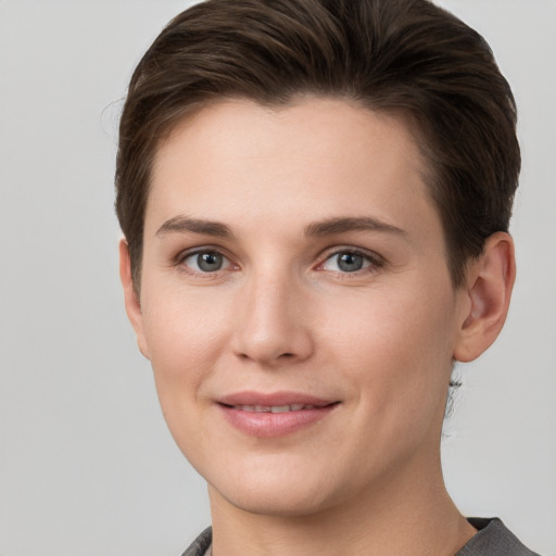 Joyful white young-adult female with short  brown hair and grey eyes