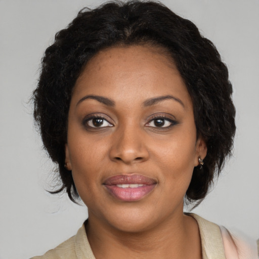Joyful black adult female with long  brown hair and brown eyes