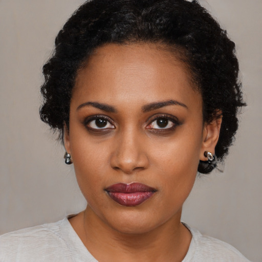 Joyful black young-adult female with short  black hair and brown eyes