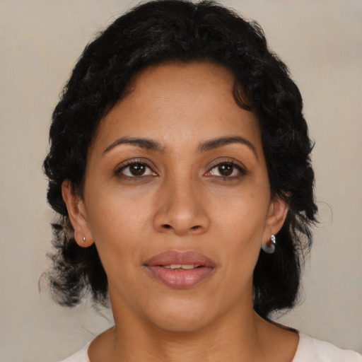 Joyful latino adult female with medium  black hair and brown eyes