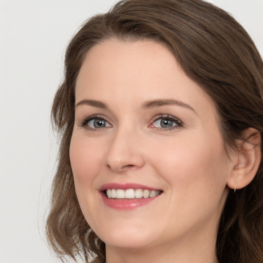 Joyful white young-adult female with long  brown hair and grey eyes