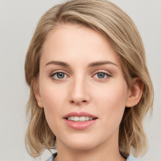 Joyful white young-adult female with medium  brown hair and blue eyes