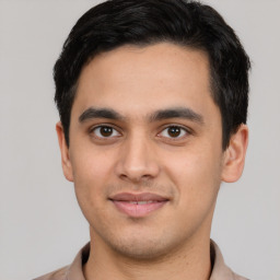 Joyful latino young-adult male with short  black hair and brown eyes