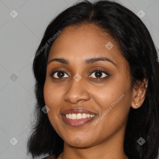 Joyful black young-adult female with long  black hair and brown eyes