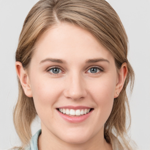 Joyful white young-adult female with medium  brown hair and blue eyes