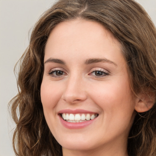 Joyful white young-adult female with long  brown hair and green eyes