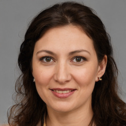 Joyful white adult female with long  brown hair and brown eyes