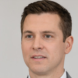 Joyful white adult male with short  brown hair and brown eyes