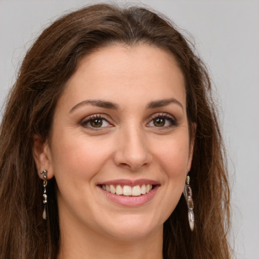 Joyful white young-adult female with long  brown hair and green eyes