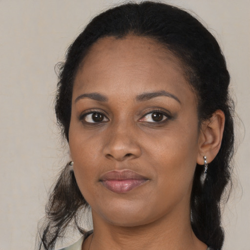 Joyful black young-adult female with long  brown hair and brown eyes