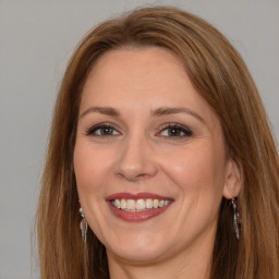 Joyful white adult female with long  brown hair and brown eyes