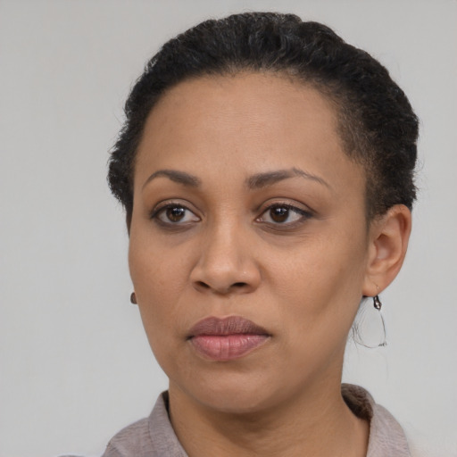 Joyful black adult female with short  brown hair and brown eyes