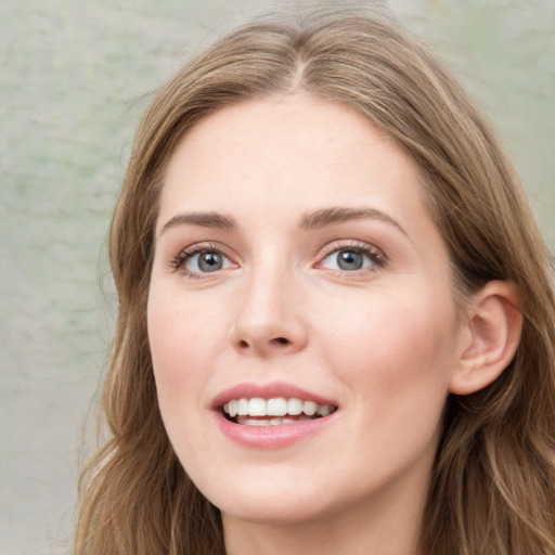 Joyful white young-adult female with long  brown hair and green eyes