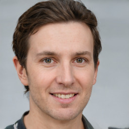 Joyful white adult male with short  brown hair and grey eyes