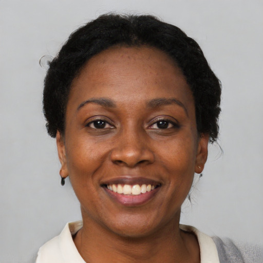 Joyful black adult female with short  black hair and brown eyes