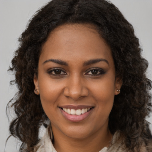 Joyful black young-adult female with long  brown hair and brown eyes