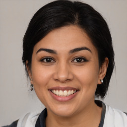 Joyful latino young-adult female with medium  brown hair and brown eyes