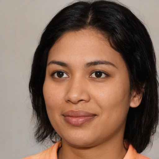 Joyful latino young-adult female with medium  black hair and brown eyes