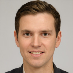 Joyful white young-adult male with short  brown hair and grey eyes