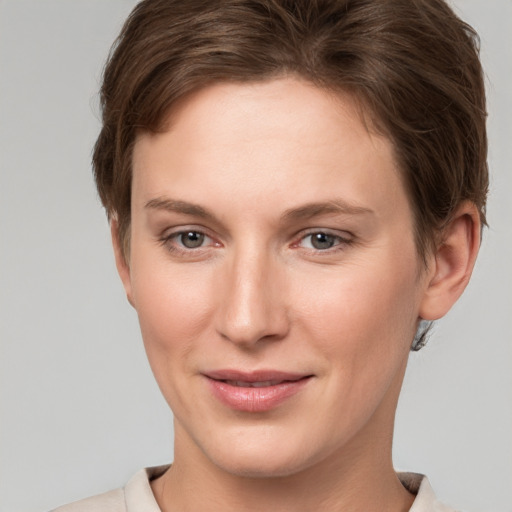 Joyful white young-adult female with short  brown hair and grey eyes