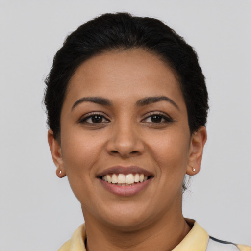 Joyful latino young-adult female with short  black hair and brown eyes