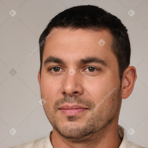 Joyful white young-adult male with short  black hair and brown eyes